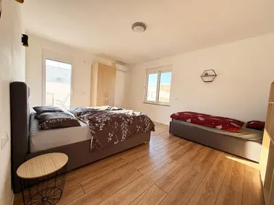 a bedroom with two beds and a wooden floor at Donji Stoj Rene Villa in Donji Štoj