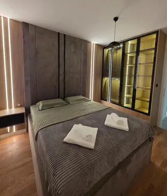 a bedroom with a bed with two white towels on it at Apartman AS in Podgorica