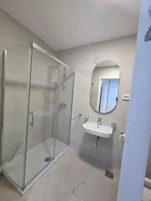 a bathroom with a shower and a sink and a mirror at Apartman AS in Podgorica