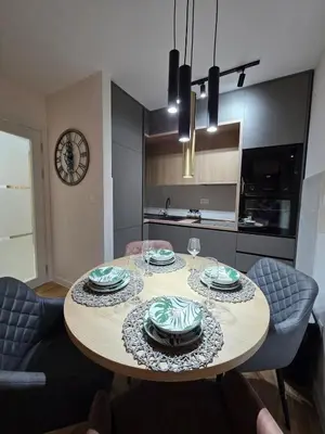 a dining room table with plates on it in a kitchen at Apartman AS in Podgorica