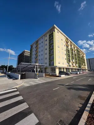 a large white building on a street with a parking lot at Apartman AS in Podgorica
