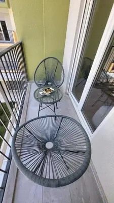 a patio with a table and a chair and a wheel at Apartman AS in Podgorica