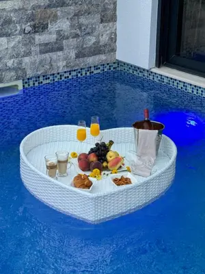 a round table with food and drinks in a pool at Villa Nova Bar in Bar