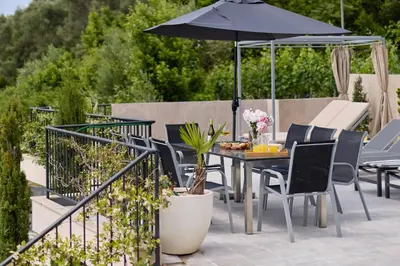 a table and chairs with an umbrella on a patio at Villa Oaza with Outdoor Pool in Kotor
