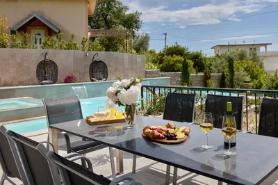 a table with a plate of food and two glasses of wine at Villa Oaza with Outdoor Pool in Kotor