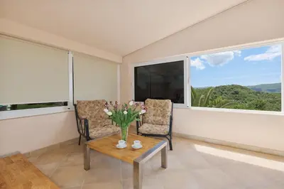 a living room with two chairs and a table and a large window at Villa Oaza with Outdoor Pool in Kotor