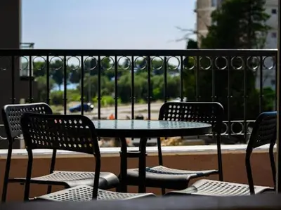 a table and chairs with a view of a balcony at Apartman Adriatico 10 in Bar, Susanj