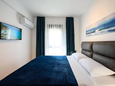 a bedroom with a large bed and a window at Apartman Adriatico 10 in Bar, Susanj
