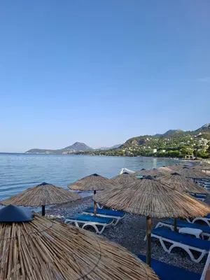 a group of straw umbrellas and chairs on a beach at Apartman Adriatico 10 in Bar, Susanj