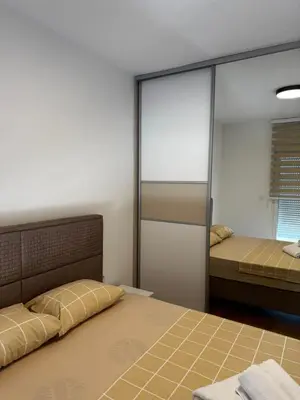 a bedroom with two beds and a mirror at Apartmani Odmor in Podgorica