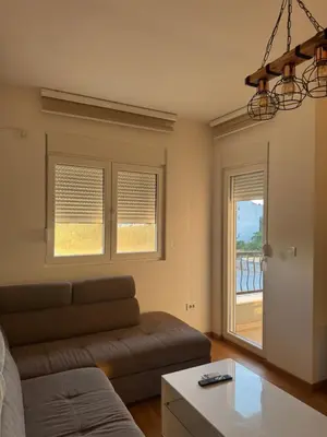 a living room with a couch and a window at Apartmani Odmor in Podgorica