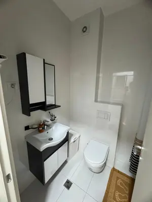 a white bathroom with a toilet and a sink at Apartmani Odmor in Podgorica