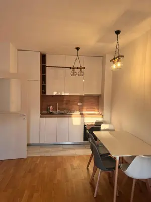 a kitchen and dining room with a table and chairs at Apartmani Odmor in Podgorica