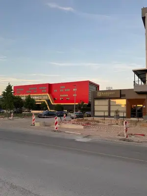 a red building in front of a parking lot at Apartmani Odmor in Podgorica
