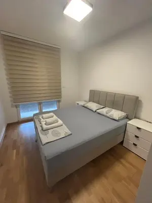 a small bedroom with a bed and a window at Apartmani Odmor in Podgorica