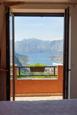 a room with a view of the ocean from a balcony at Big Hill Apartment 2 in Kotor
