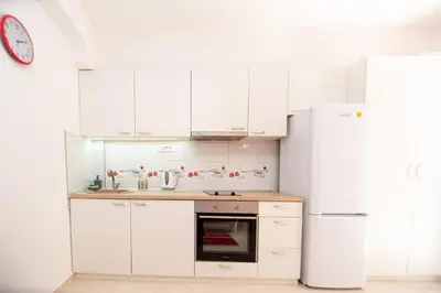 a kitchen with white cabinets and a refrigerator at KlubNika in Budva