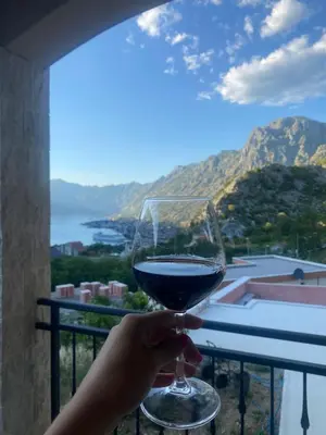 a person holding a glass of wine in front of a window at Azure Boka in Trojica