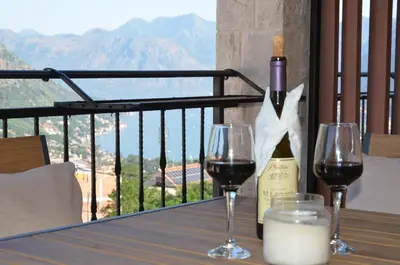two glasses of wine on a table with a bottle of wine at Azure Boka in Trojica