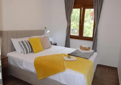 a bedroom with a bed with a yellow blanket on it at Azure Boka in Trojica