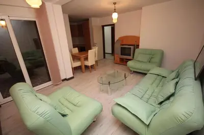a living room with two green couches and a table at Lotos in Dobra Voda