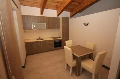 a kitchen with a table and chairs in a room at Lotos in Dobra Voda