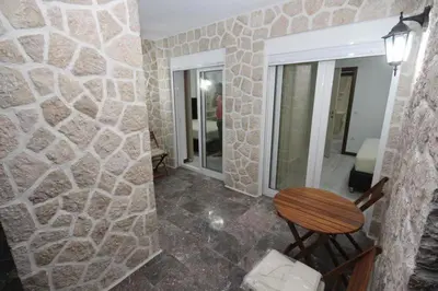 a room with a stone wall with a chair and a mirror at Lotos in Dobra Voda