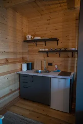 a kitchen with a sink in a wooden cabin at Villa Baccarat in Ulcinj