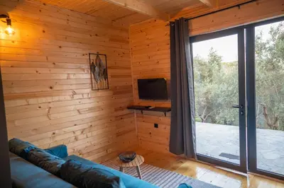 a living room with a couch and a tv and a window at Villa Baccarat in Ulcinj