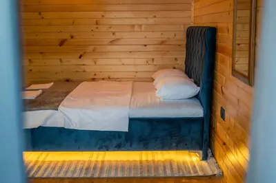 a bed in a wooden room with a wooden wall at Villa Baccarat in Ulcinj