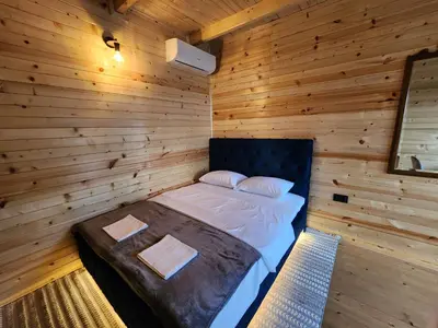 a bedroom with a bed in a wooden wall at Villa Baccarat in Ulcinj