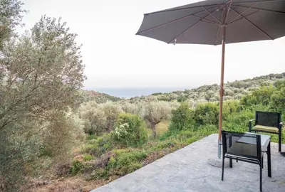 a patio with an umbrella and two chairs and a table at Villa Baccarat in Ulcinj