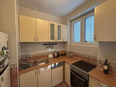 a kitchen with white cabinets and a sink at Central Kotor Bay Condo with amazing view in Kotor