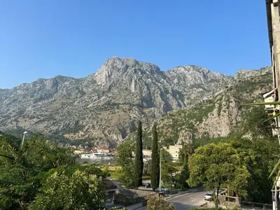 a mountain in the distance with a road and trees at Central Kotor Bay Condo with amazing view in Kotor