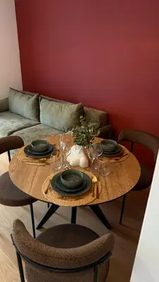 a wooden table with plates and wine glasses on it at Becici Green Oasis Apartment - Nature & Comfort in Becici