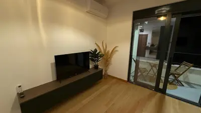 a living room with a flat screen tv next to a window at Becici Green Oasis Apartment - Nature & Comfort in Becici