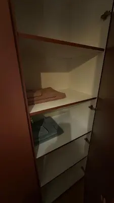 a closet with glass shelves and a towel on it at Becici Green Oasis Apartment - Nature & Comfort in Becici