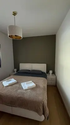 a bedroom with a bed with two towels on it at Becici Green Oasis Apartment - Nature & Comfort in Becici
