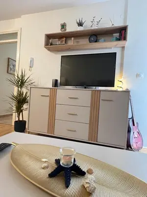 a living room with a tv and a table at Ilirija Budva Center Sea Style in Budva