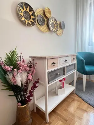 a living room with a table with plates on the wall at Ilirija Budva Center Sea Style in Budva