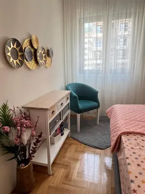 a bedroom with a desk and a green chair at Ilirija Budva Center Sea Style in Budva