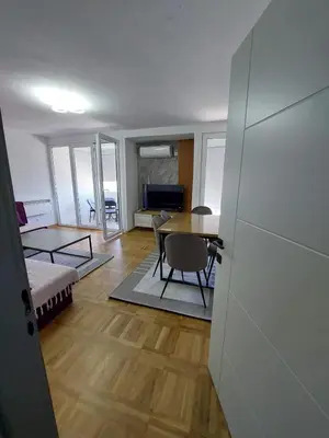 a living room with a table and a dining room at Golden view apartman in Bar