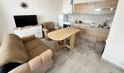 a living room with a couch and a table and a kitchen at Vaidas place in Ulcinj
