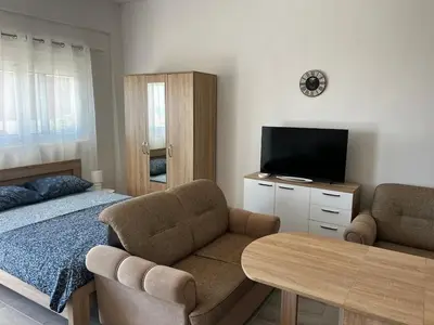 a bedroom with a bed and a couch and a television at Vaidas place in Ulcinj