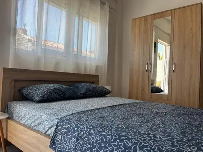 a bedroom with a bed and a wooden cabinet at Vaidas place in Ulcinj