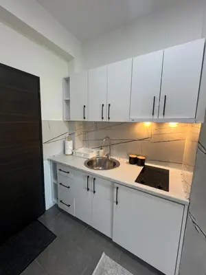a kitchen with white cabinets and a sink at Apartments Nesi in Ulcinj