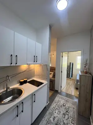 a kitchen with white cabinets and a sink at Apartments Nesi in Ulcinj
