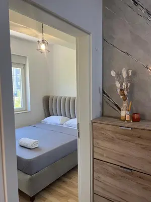 a bedroom with a king sized bed and a dresser at Apartments Nesi in Ulcinj