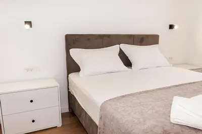 a bed with white sheets and pillows in a bedroom at Konzul apartment in Kotor
