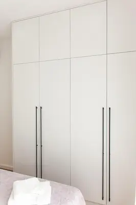 a white bedroom with white cabinets and a bed at Konzul apartment in Kotor